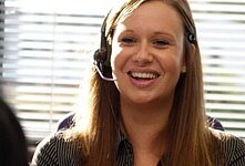 Photograph of a woman wearing a headset in a call centre